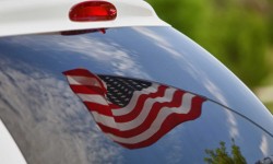 A photo of an American flag reflecting in an emergency vehicle windshield.